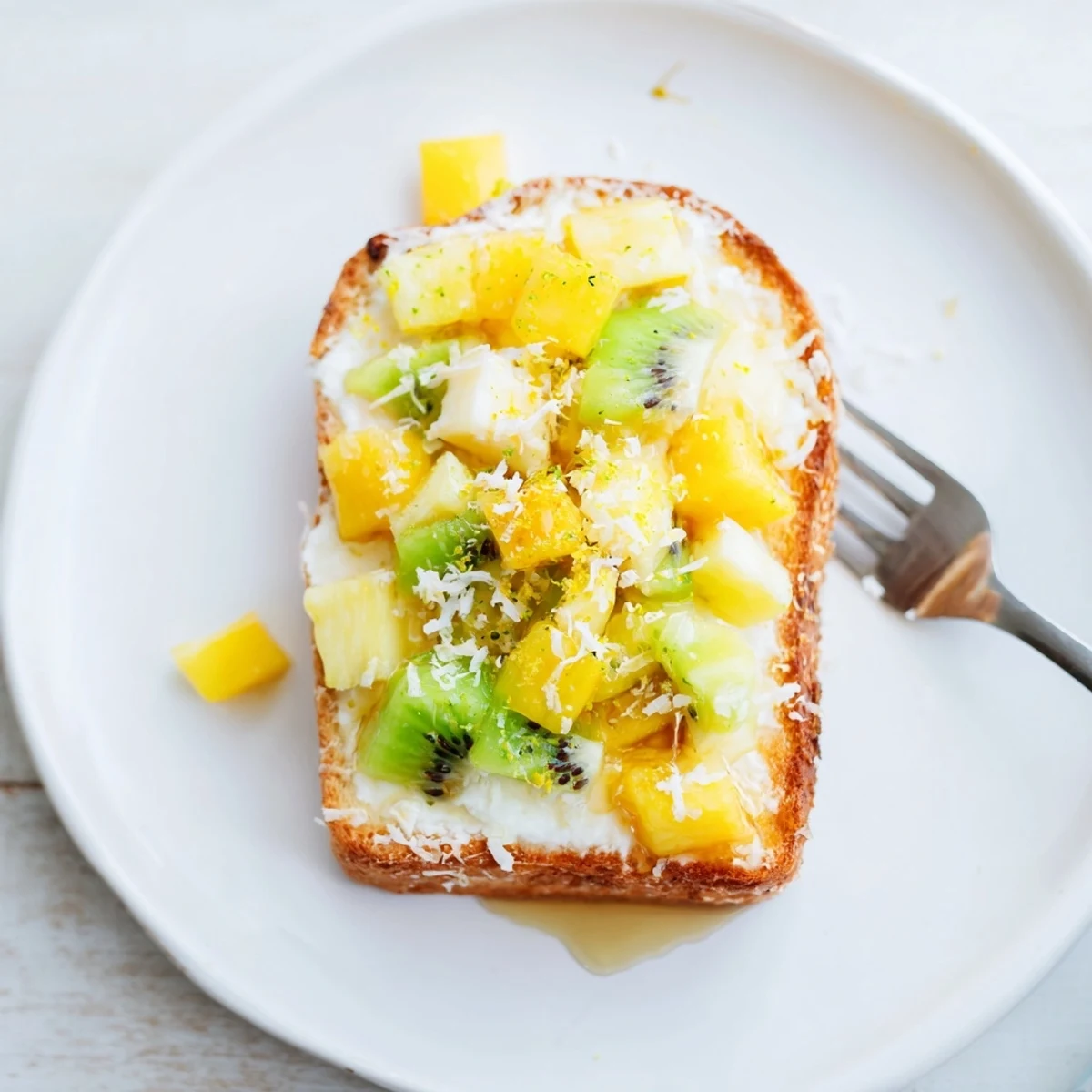 Vibrant yogurt-custard toast topped with tropical fruits for a delicious breakfast.  