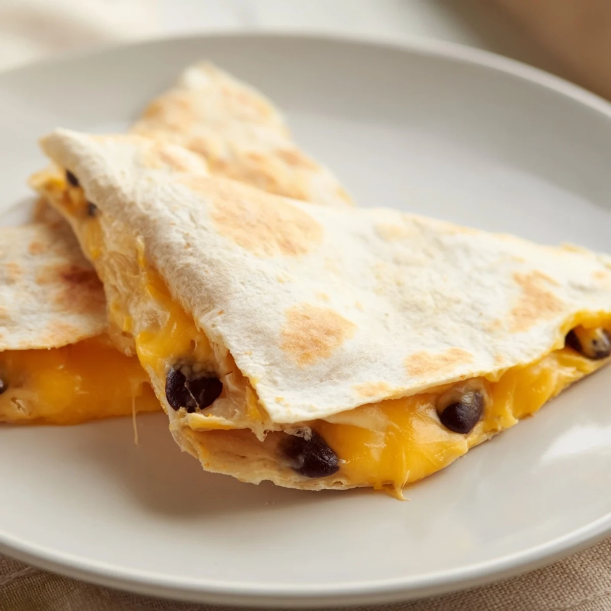 Warm and flavorful bean & cheese quesadillas with a perfectly browned tortilla and creamy filling.
