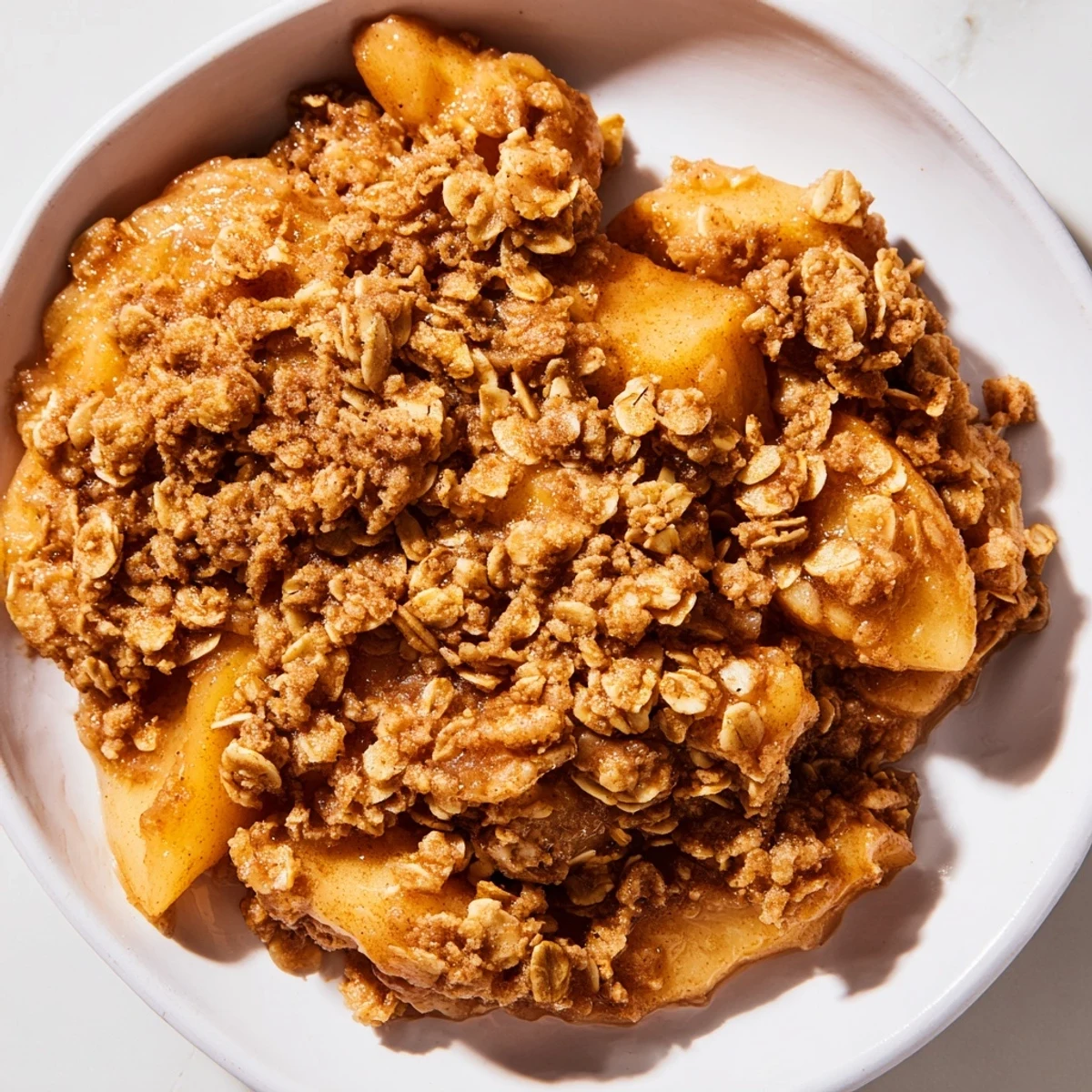 Golden-brown Apple Crisp shows juicy baked apples under a warm, buttery oat topping.