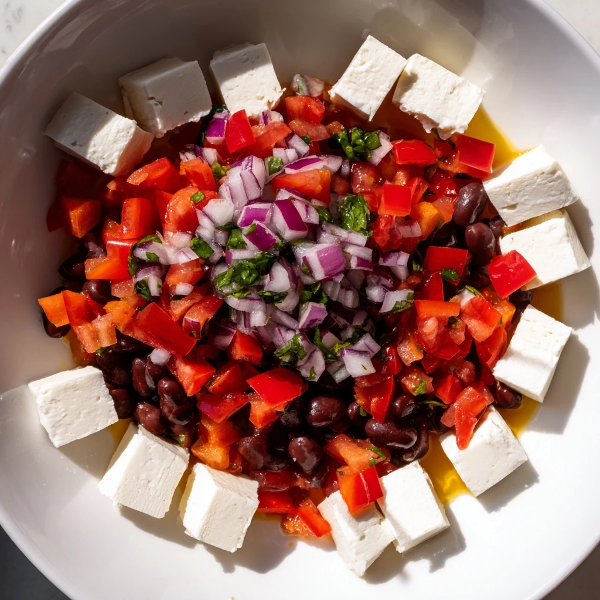 Fresh black bean salsa spooned over spicy Pepper Jack cheese cubes, perfect for appetizers.