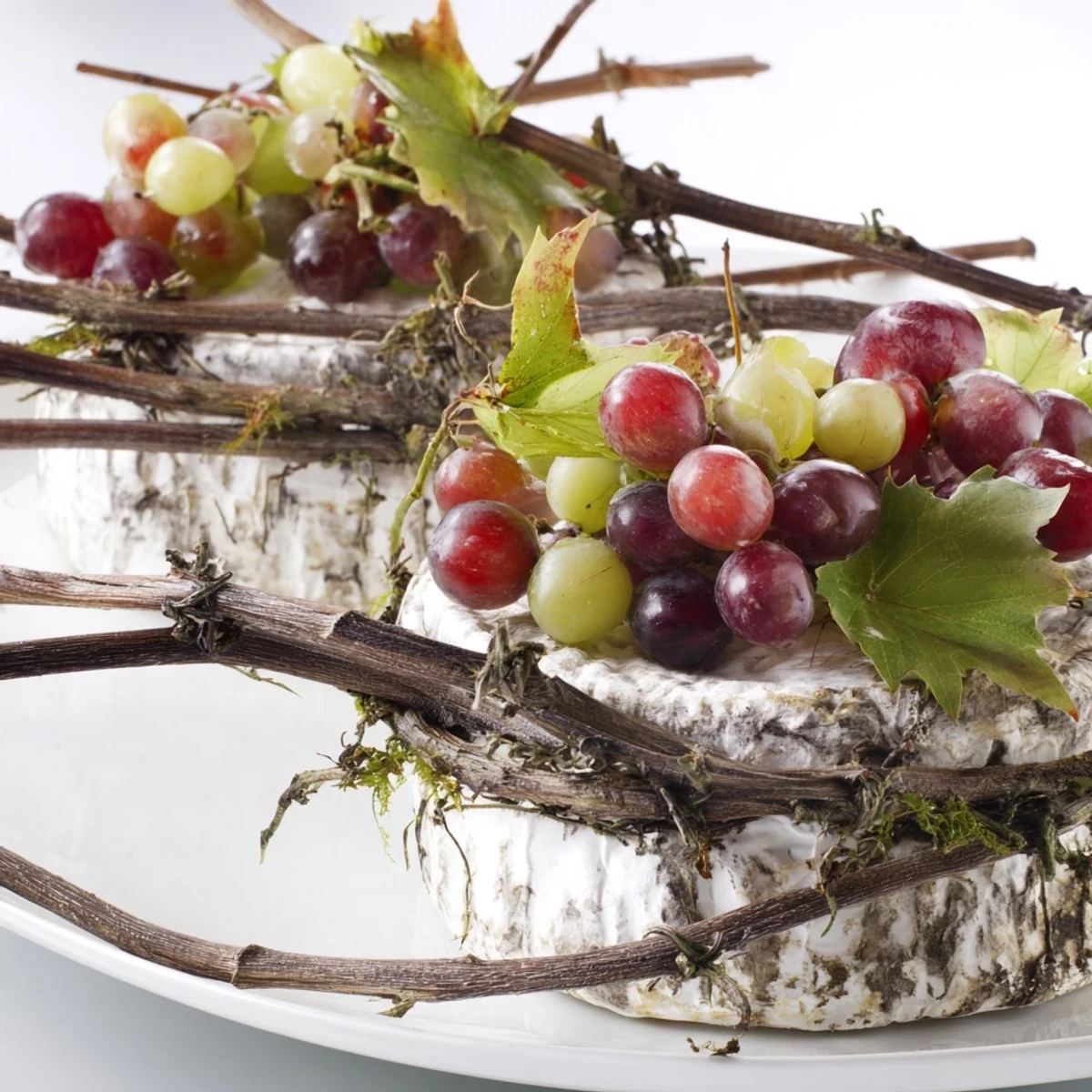 Rustic Vineyard cheese arrangement with fresh grapes and grapevine, ready to serve and enjoy.