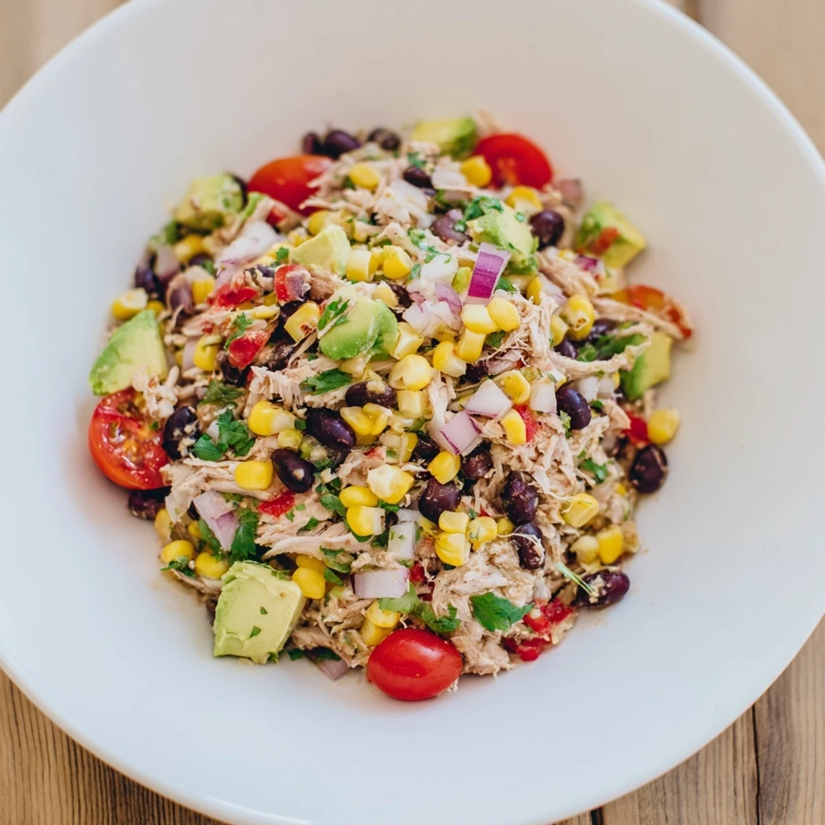 Close-up of a refreshing Dense Southwestern Bean Salad, with creamy avocado and zesty dressing.