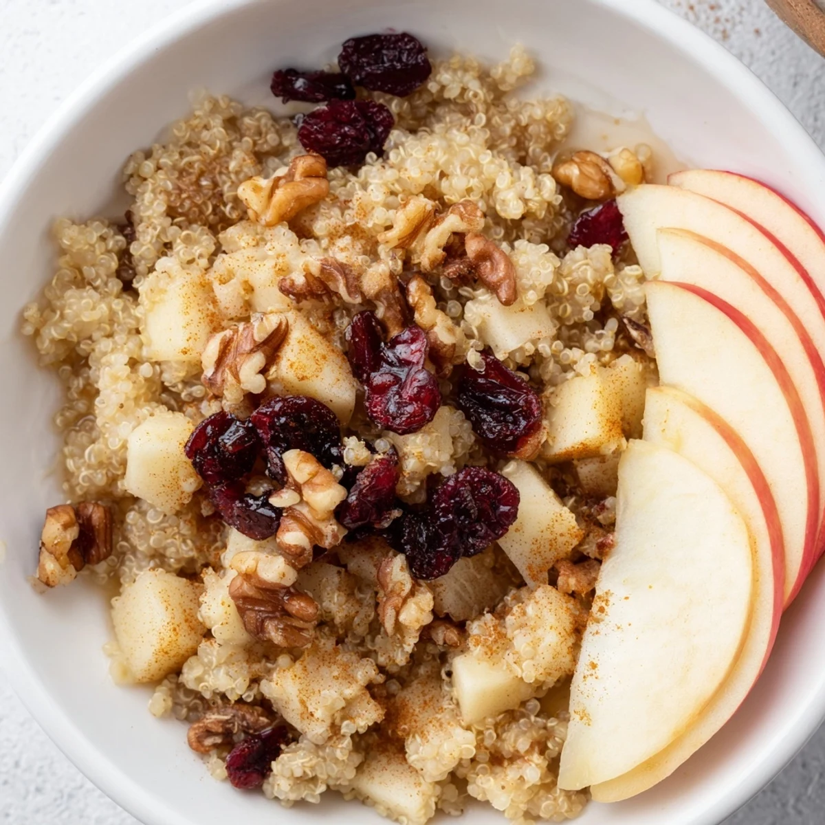 A close-up of a warm Apple Cinnamon Quinoa Bowl, beautifully garnished, ready to enjoy this morning.