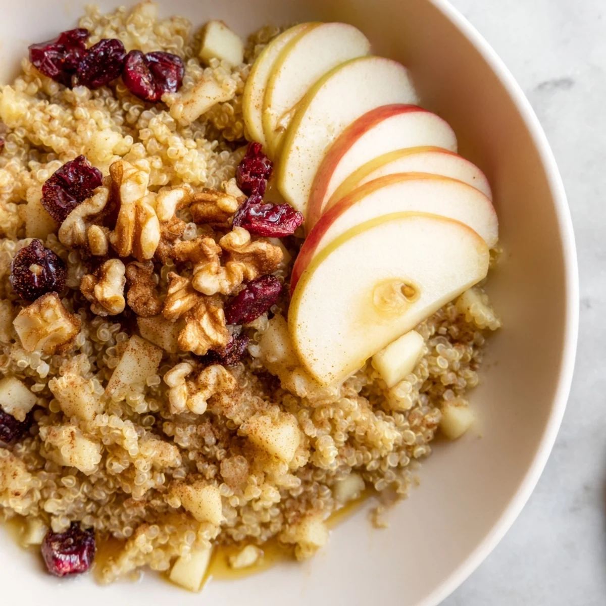 Steaming Apple Cinnamon Quinoa Bowl, a healthy breakfast overflowing with sweet apples and pecans.