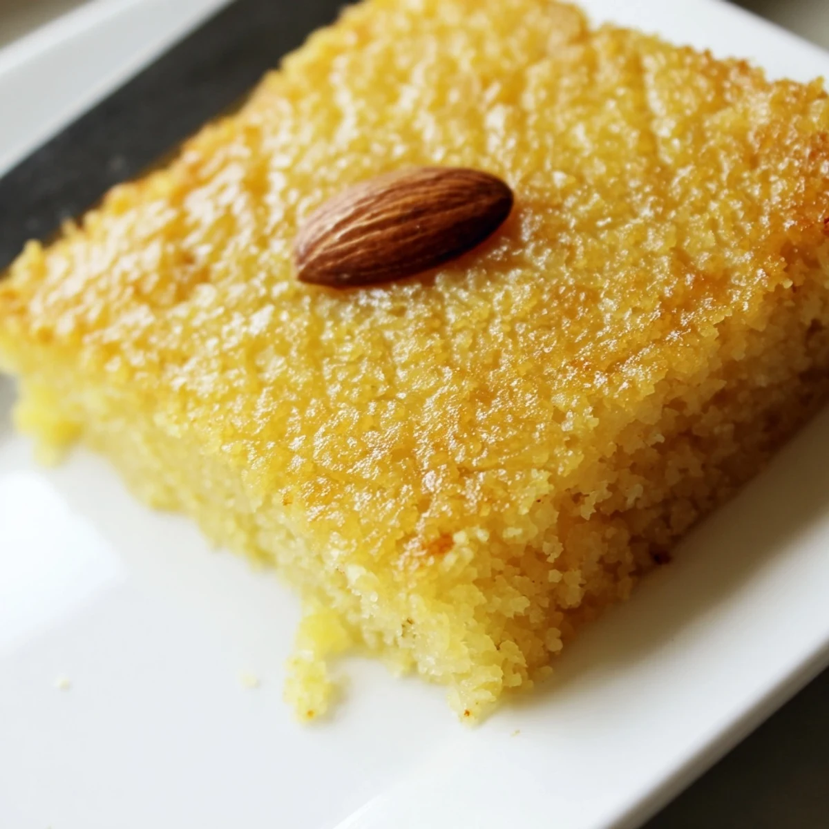 Warm, sweet aroma of coconut and syrup emanates from freshly poured Basbousa cake.