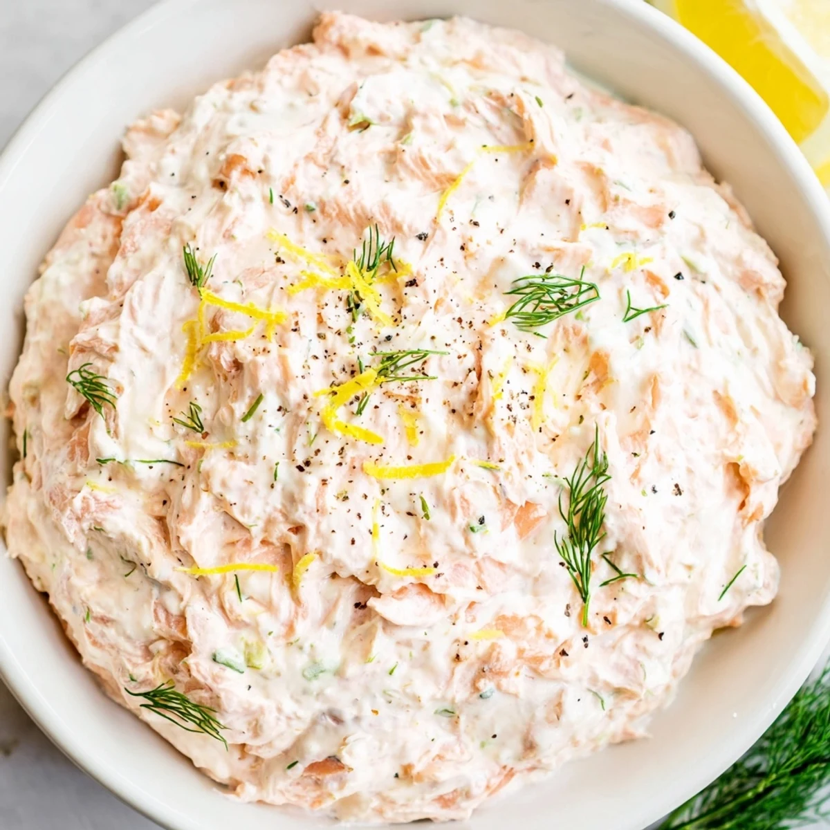 Creamy smoked salmon dip, a delightful appetizer with vibrant green herbs and smoky salmon.
