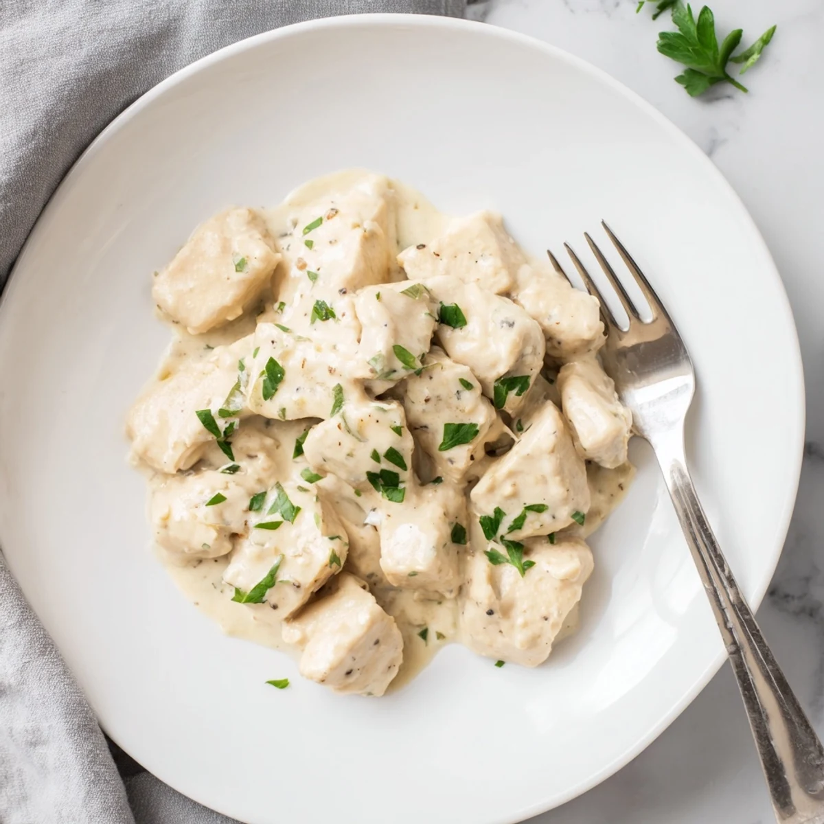 Tender golden chicken bites coated in a rich, garlicky cream sauce with fresh parsley, perfect for a quick weeknight dinner.