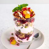 Vibrant Christmas Pudding Yogurt Parfait Bar with berry compote and crunchy granola alongside fresh fruit.