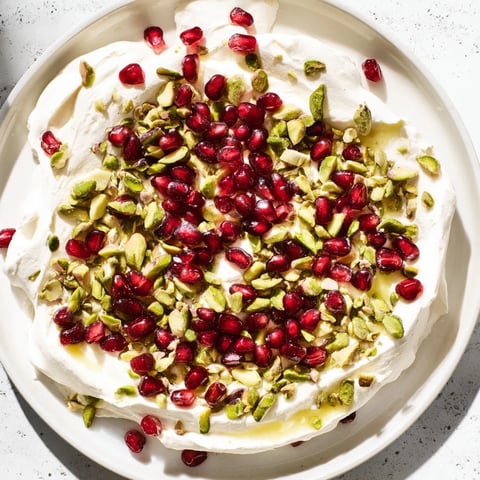 Frozen yogurt bark with juicy pomegranate seeds and crunchy pistachios, a cool and creamy dessert.