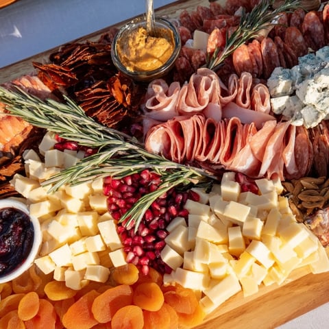Winter Forest Charcuterie Scene: A beautifully arranged board of meats, cheeses, and garnishes, perfect for a gathering.