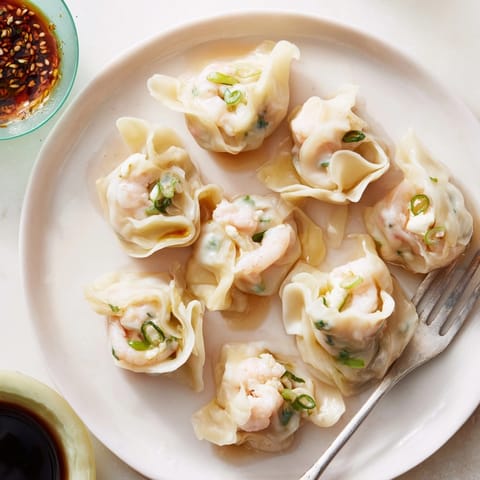 Homemade cheesy shrimp scallion dumplings, a savory Asian-fusion appetizer, perfect with vibrant dipping sauces.