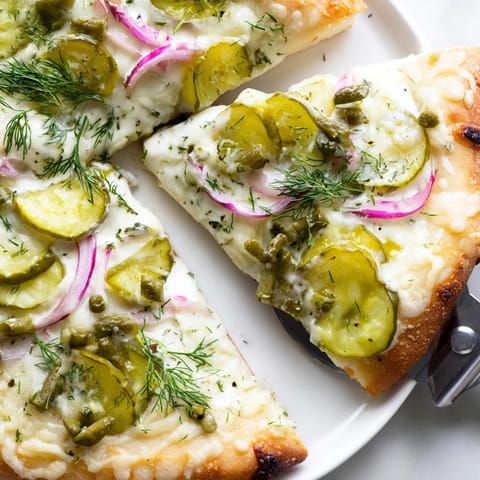 Deliciously cheesy Pickle Pizza served hot with crunchy dill pickle slices.  