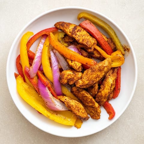 These Sheet-Pan Chicken Fajitas feature tender chicken and veggies cooked to perfection with smoky spices.