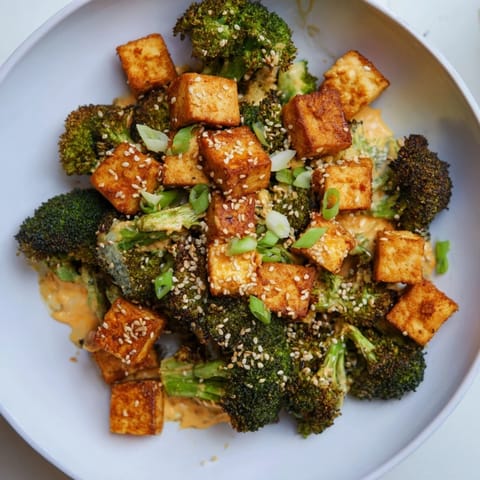 A bubbling casserole of Cheesy Baked Tofu and Broccoli, topped with sesame seeds for added flavor.