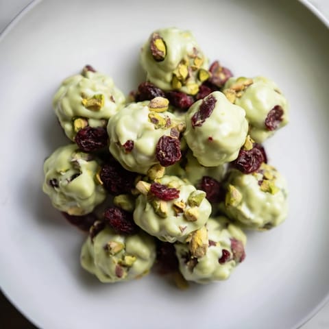 Melting white chocolate infused with bright matcha powder and tart cranberries forms these delightful Matcha Bark Clusters.