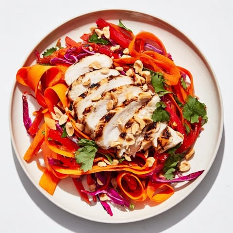 Freshly assembled Carrot Ribbon and Chicken Slaw bursting with color, drizzled with a creamy ginger-miso dressing.