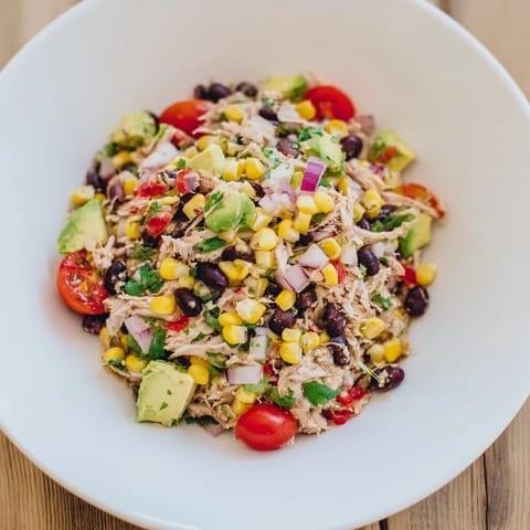 Close-up of a refreshing Dense Southwestern Bean Salad, with creamy avocado and zesty dressing.
