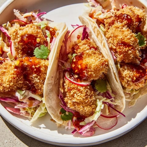 Close-up of freshly made Hot Honey Chicken Tacos, showcasing the layers of texture and color.
