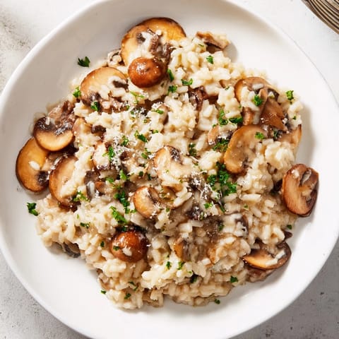 A close-up of the finished risotto with mushrooms, garnished with fresh parsley and Parmesan.