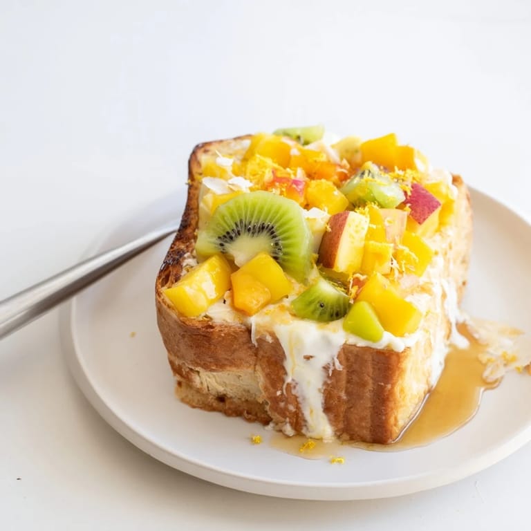 Sliced brioche Yogurt-Custard Toast drizzled with honey and piled high with kiwi.