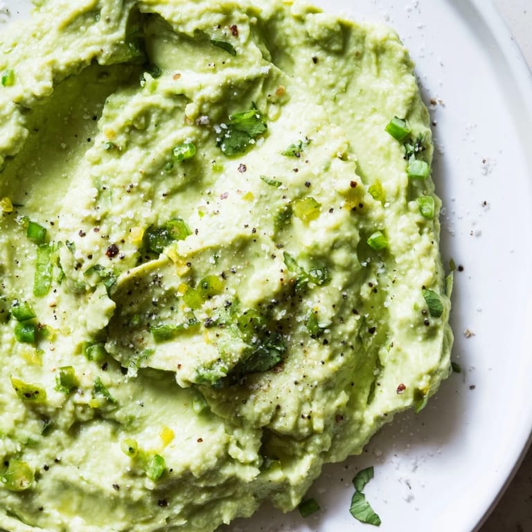 A bowl filled with vibrant Avocado Lime Dip, creamy and flavorful, ideal as a flavorful appetizer.