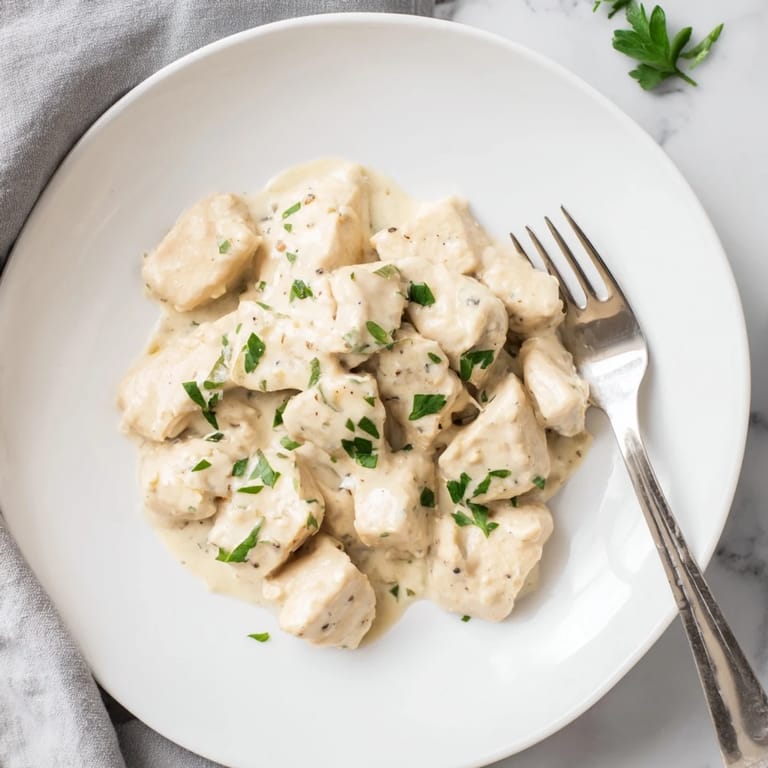 Tender golden chicken bites coated in a rich, garlicky cream sauce with fresh parsley, perfect for a quick weeknight dinner.
