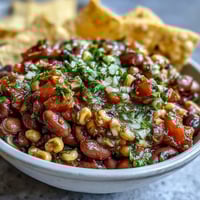 Three-Ingredient Cowboy Caviar Dip in a colorful bowl with tortilla chips on the side.  