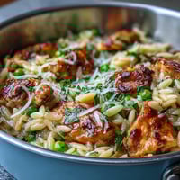 One-Pot Lemon Orzo with Chicken and Peas in a creamy skillet, topped with fresh parsley and Parmesan.
